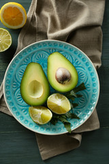 Sliced avocado and lemon lime on wooden background