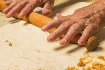 Old woman making a bread with cracklings