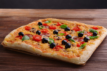 Delicious homemade pizza on table on black background