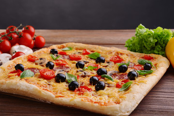 Delicious homemade pizza on table on black background