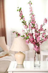 Spring bouquet in vase, on table, on home interior background