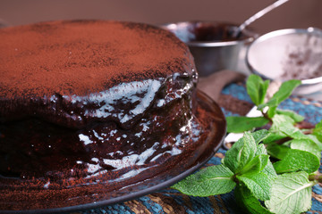Delicious chocolate cake with icing in plate on table, closeup