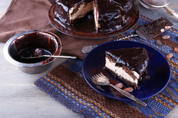 Delicious chocolate cake with icing in plate on table, closeup