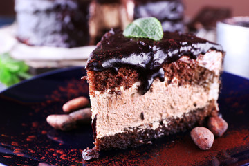 Delicious chocolate cake with icing in plate on table, closeup