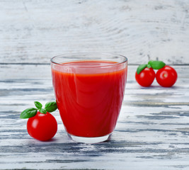 Glass of tomato juice with vegetables on wooden background