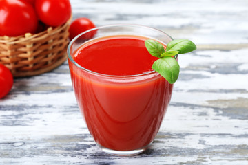 Glass of tomato juice with vegetables on wooden background