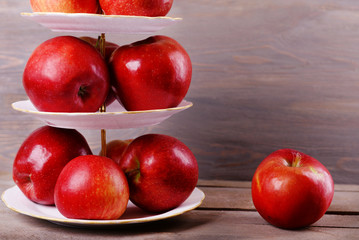 Tasty ripe apples on serving tray on wooden background