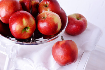 Tasty ripe apples on serving tray on brick wall background