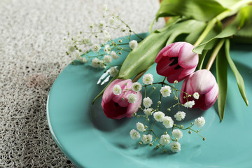 Tableware with flowers on table close up