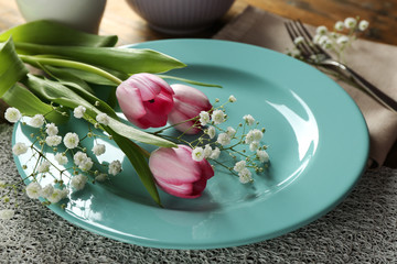 Obraz na płótnie Canvas Tableware with flowers on table close up