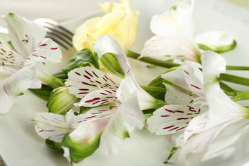 Tableware with flowers on table close up
