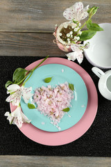 Tableware with flowers on table close up