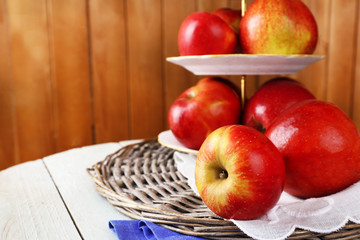 Tasty ripe apples on serving tray on wooden background