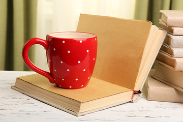 Books and cup on wooden table, closeup