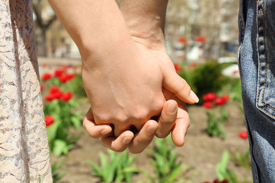Couple holding hands on blurred background