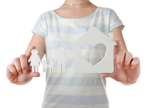 Female hands with small model of house and family isolated on white