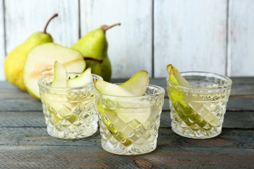 Pear juice with fresh fruits on wooden background