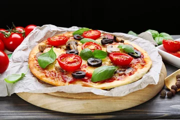 Foto op Plexiglas Lekkere pizza met groenten en basilicum op tafel close-up © Africa Studio