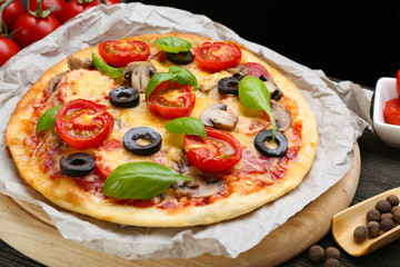 Tasty pizza with vegetables and basil on table close up