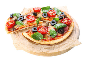 Tasty pizza with vegetables and basil on cutting board isolated on white