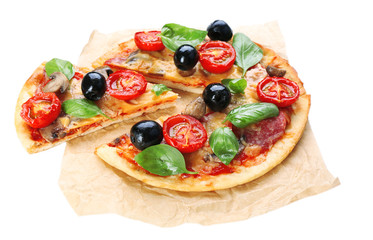 Tasty pizza with vegetables and basil on paper isolated on white