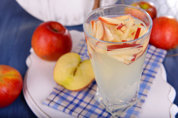 Glass of apple cider with fruits on table close up