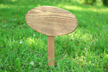 Wooden signboard over grass, outdoors