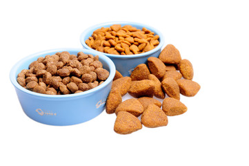 Blue ceramic dogs bowl. Dry dog food in bowl isolated on white background.