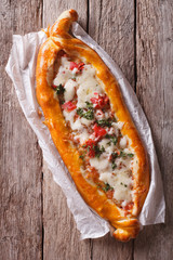 Hot Turkish pide pizza closeup on a table. vertical top view
