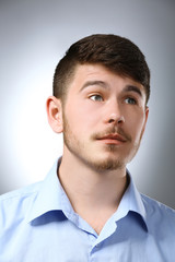 Fototapeta premium Portrait of thoughtful man on gray background