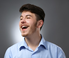 Fototapeta premium Portret uśmiechnięty mężczyzna na szarym tle