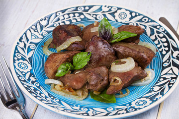Sauteed liver with onions on blue plate