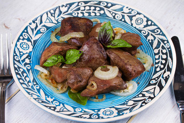 Sauteed liver with onions on blue plate