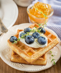 Homemade fresh crispy waffles for breakfast with blueberries and honey