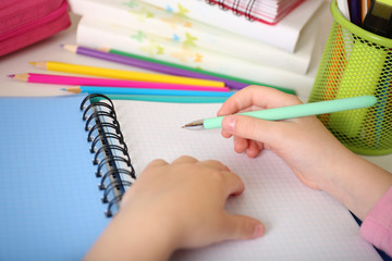 Kids hands drawing on notebook at desktop, closeup