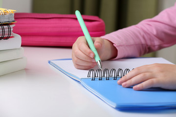 Kids hands drawing on notebook at desktop, closeup