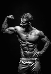 Obraz na płótnie Canvas very muscular handsome athletic man on black background