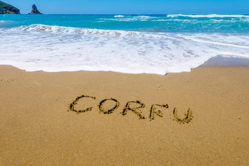 Corfu written on golden  beach, Agios Gordis, Corfu, Greece. Selective focus.