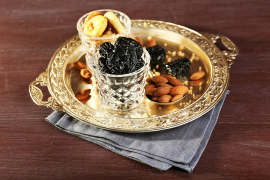 Dried fruits in glasses on metal tray, closeup