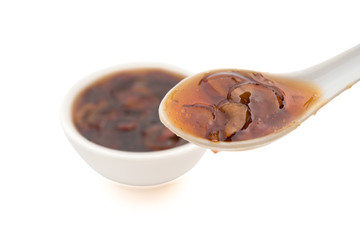 taking out a spoon of Chinese traditional medical jujube soup on white background