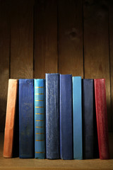 Naklejka premium Old books on shelf, close-up, on dark wooden background