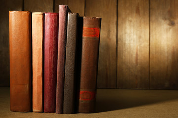 Naklejka premium Old books on shelf, close-up, on dark wooden background