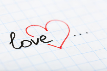 Word LOVE with heart written on sheet of paper background