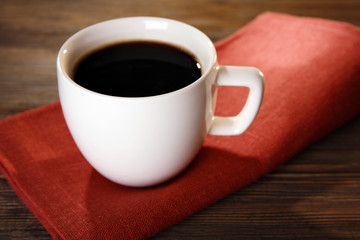 Cup of coffee on napkin on table close up