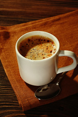 Cup of coffee on napkin on table close up