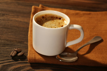 Cup of coffee on napkin on table close up