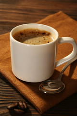 Cup of coffee on napkin on table close up