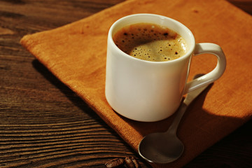 Cup of coffee on napkin on table close up