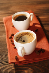 Cups of coffee on napkin on table close up