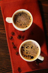 Cups of coffee on napkin on table close up